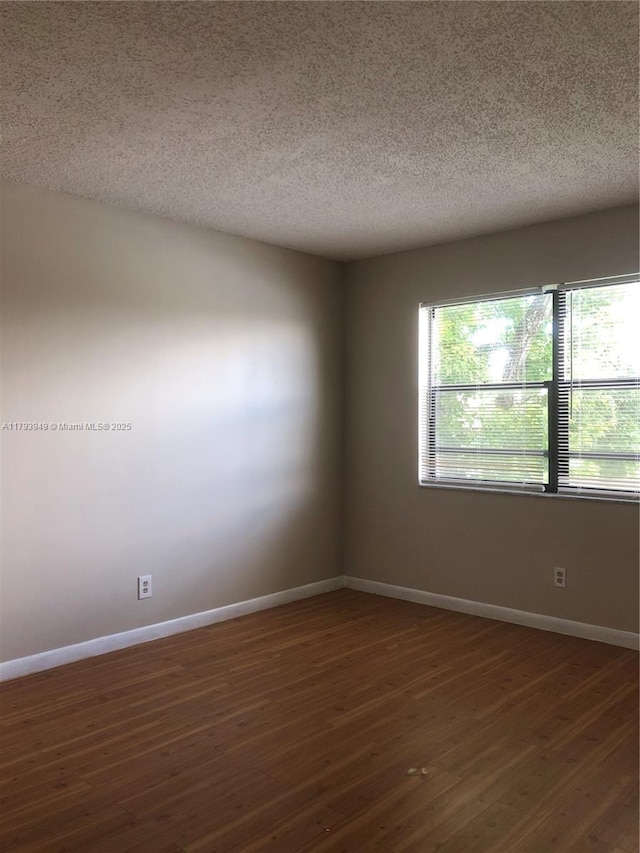 9044 NW 28th Dr Unit 3-202, Coral Springs, FL 33065 - unfurnished room featuring a textured ceiling, baseboards, and dark wood-style floors