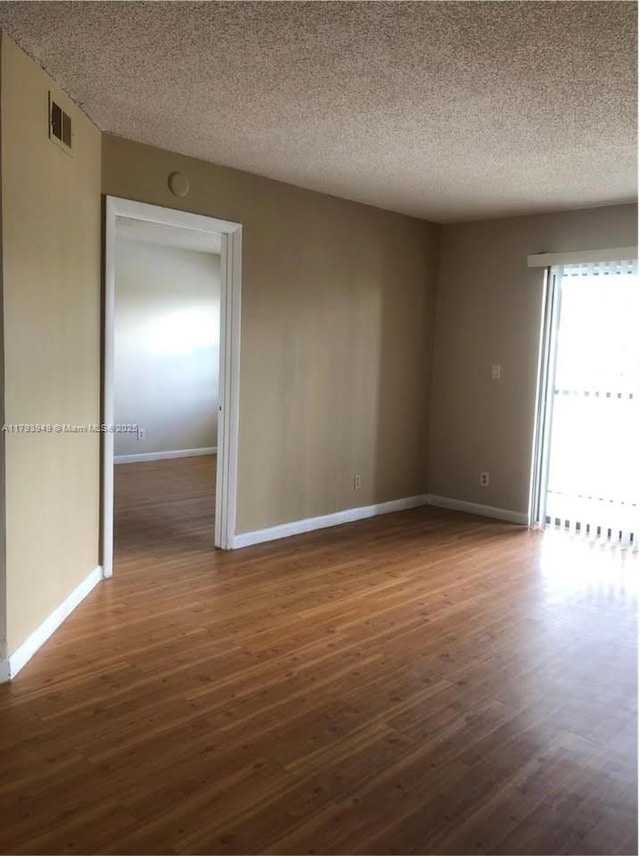 9044 NW 28th Dr Unit 3-202, Coral Springs, FL 33065 - empty room with dark wood-style flooring, baseboards, and a textured ceiling