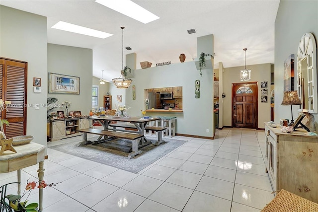 dining space with visible vents, high vaulted ceiling, light tile patterned flooring, and a skylight