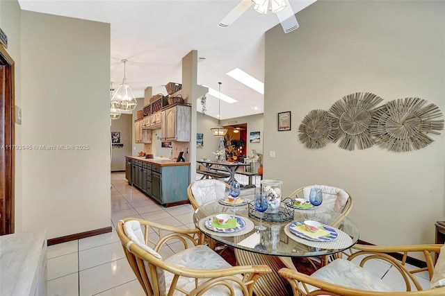 dining space featuring light tile patterned flooring, baseboards, lofted ceiling, and ceiling fan with notable chandelier