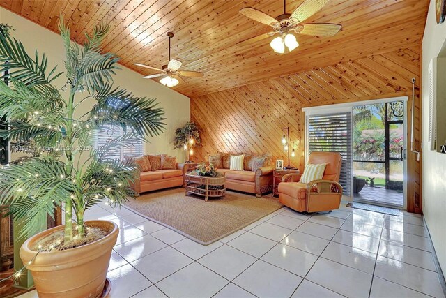 living area featuring tile patterned floors, ceiling fan, wood walls, and high vaulted ceiling