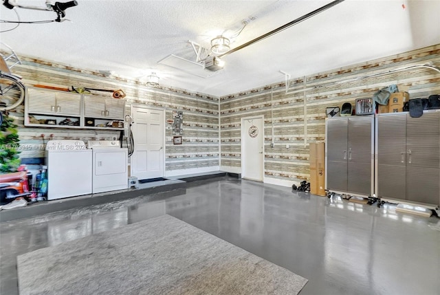 garage with independent washer and dryer and a garage door opener