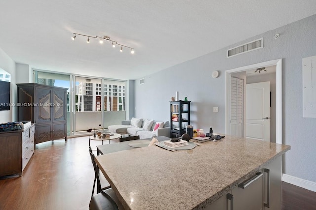 500 NE 29th St Unit 606, Miami, FL 33137 - kitchen with light stone countertops, visible vents, baseboards, and dark wood-type flooring