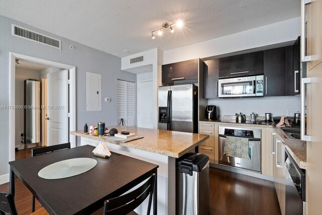 500 NE 29th St Unit 606, Miami, FL 33137 - kitchen featuring a textured ceiling, appliances with stainless steel finishes, visible vents, and dark wood-type flooring