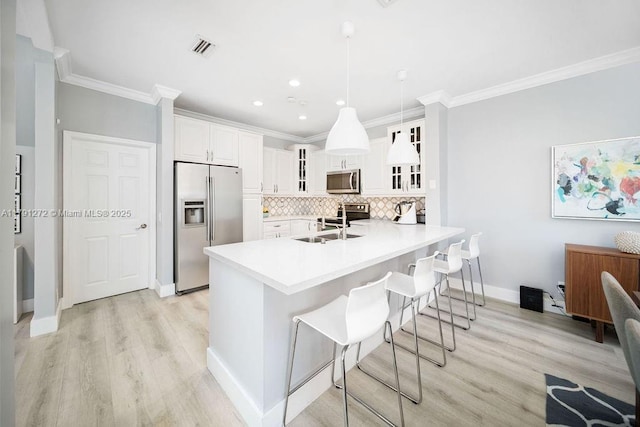 721 Tanglewood Cir, Weston, FL 33327 - kitchen featuring crown molding, glass insert cabinets, a kitchen breakfast bar, light wood finished floors, and appliances with stainless steel finishes