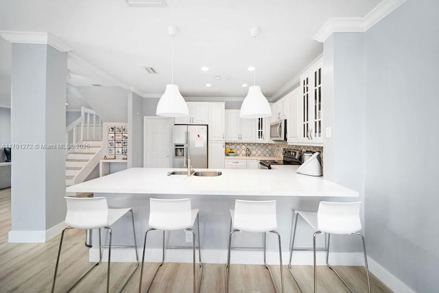 721 Tanglewood Cir, Weston, FL 33327 - kitchen with appliances with stainless steel finishes, tasteful backsplash, a sink, a peninsula, and light wood-style flooring