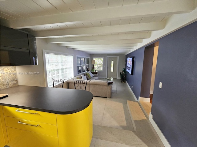 interior space featuring baseboards, light tile patterned floors, wooden ceiling, and beamed ceiling