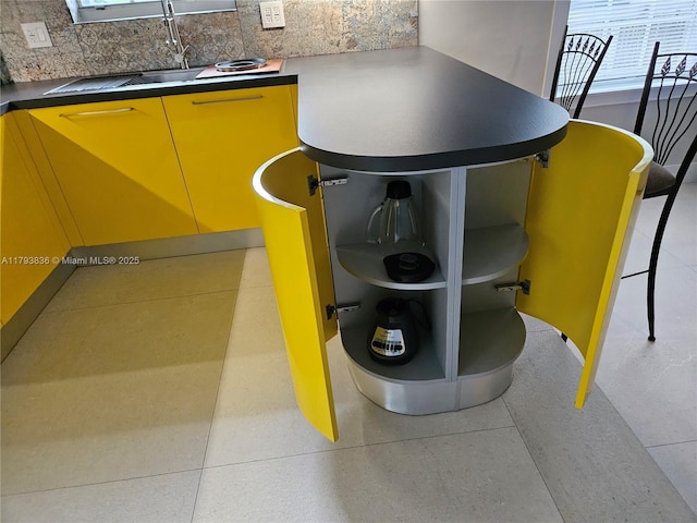interior details with decorative backsplash and a sink