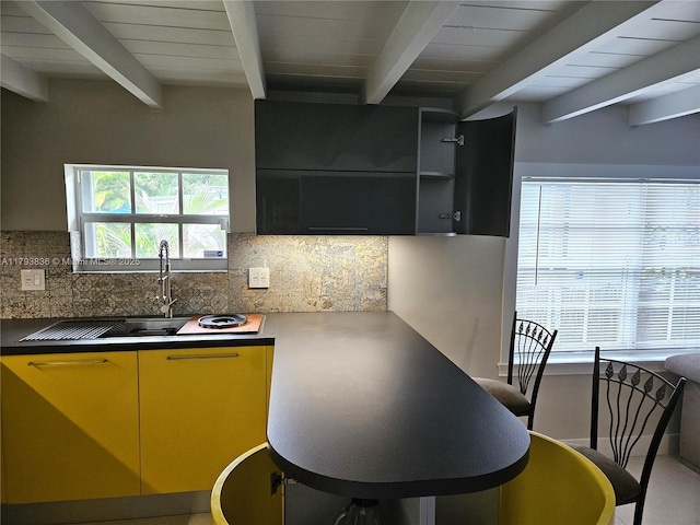 kitchen featuring backsplash, open shelves, a sink, and beam ceiling