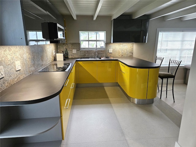 kitchen with a sink, backsplash, beam ceiling, and black electric cooktop