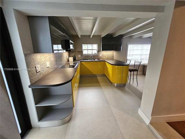 kitchen featuring beam ceiling, dark countertops, baseboards, black electric cooktop, and tasteful backsplash