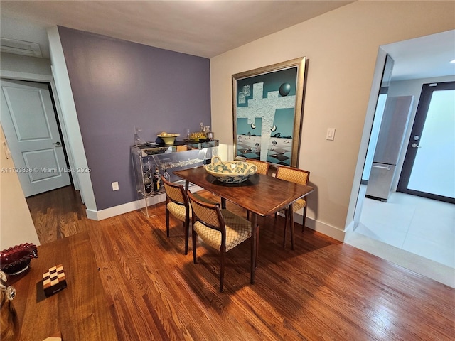 dining area with baseboards and wood finished floors