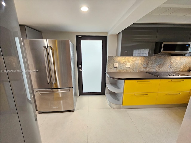 kitchen with dark countertops, appliances with stainless steel finishes, modern cabinets, and backsplash