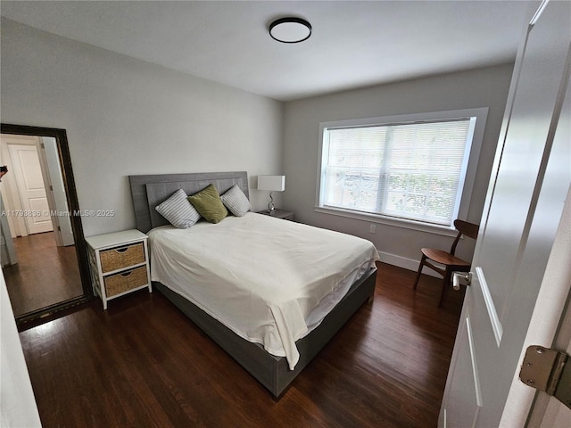 bedroom featuring baseboards and dark wood finished floors