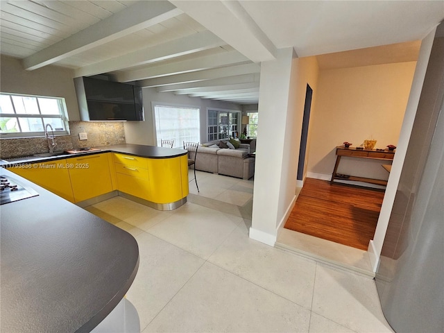 kitchen with plenty of natural light, beamed ceiling, and light tile patterned flooring