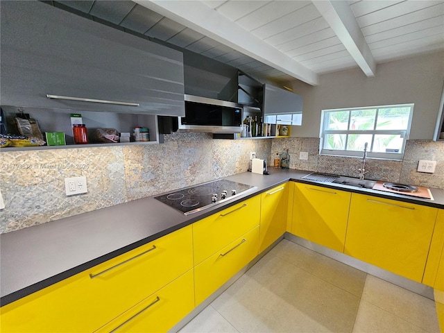 kitchen featuring black electric stovetop, beam ceiling, yellow cabinets, decorative backsplash, and light floors