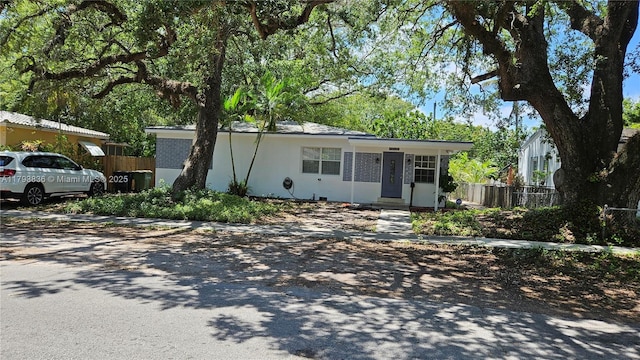ranch-style house featuring fence