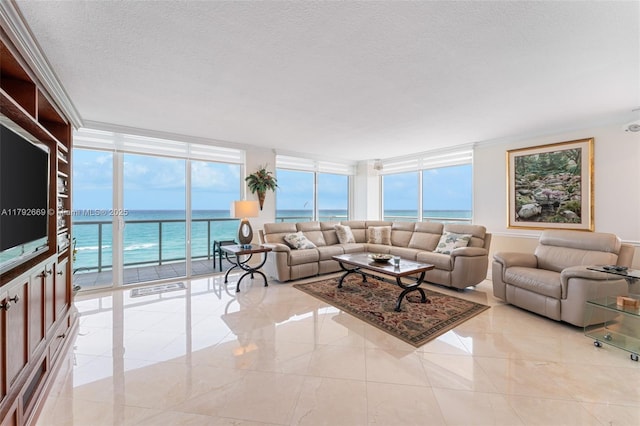 living room with a water view, a textured ceiling, and a wall of windows