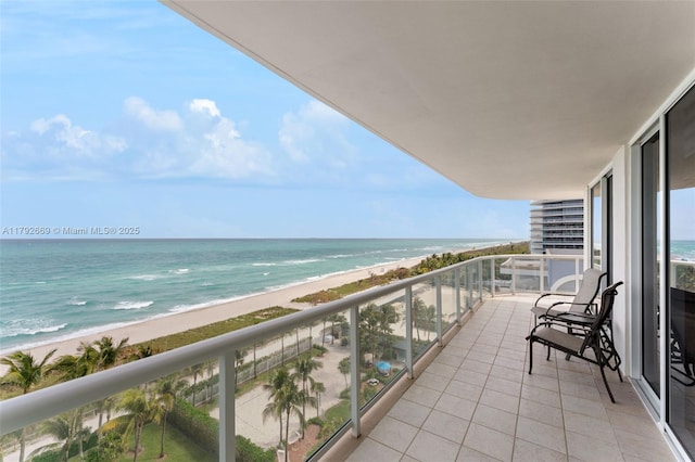 balcony with a water view and a view of the beach