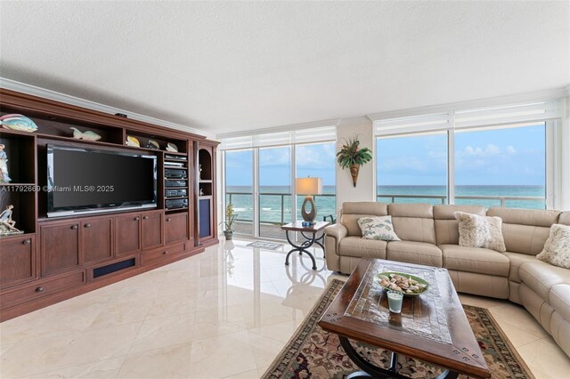 living room featuring a water view, a textured ceiling, a wall of windows, and a healthy amount of sunlight