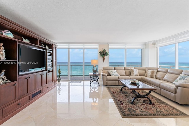 living room with a textured ceiling, floor to ceiling windows, and a water view