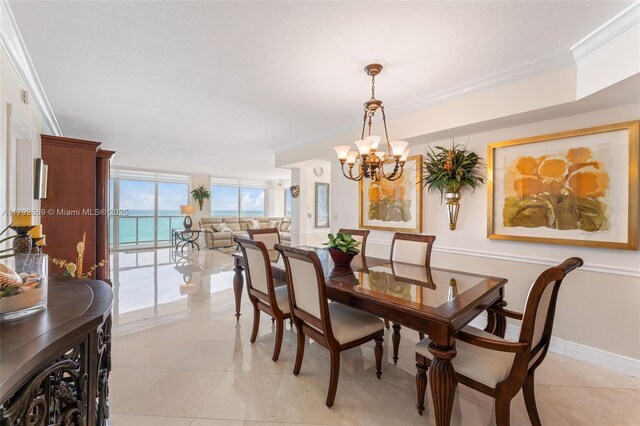 dining space with crown molding, baseboards, a water view, a chandelier, and light tile patterned floors