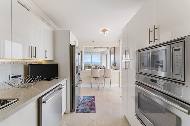 kitchen with light countertops, appliances with stainless steel finishes, modern cabinets, and white cabinets