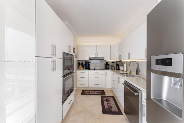 kitchen featuring white cabinets, a sink, light countertops, ornamental molding, and black appliances
