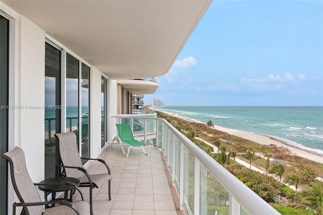 balcony featuring a water view and a view of the beach