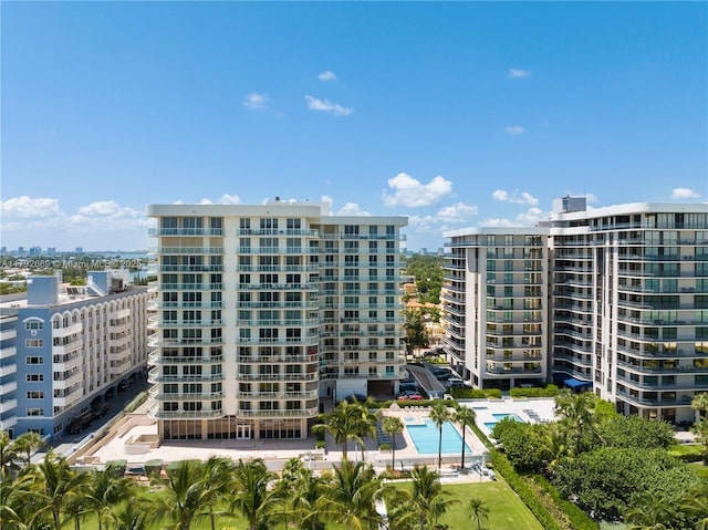 view of building exterior featuring a community pool and a city view