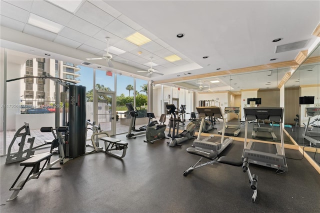 workout area featuring ceiling fan, visible vents, and a raised ceiling