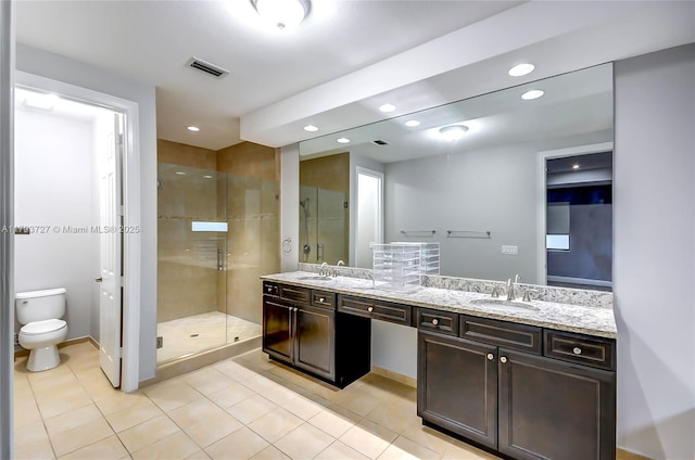 bathroom featuring a sink, a stall shower, toilet, and visible vents
