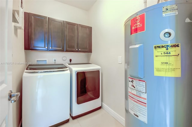 laundry area with baseboards, electric water heater, separate washer and dryer, cabinet space, and light tile patterned floors