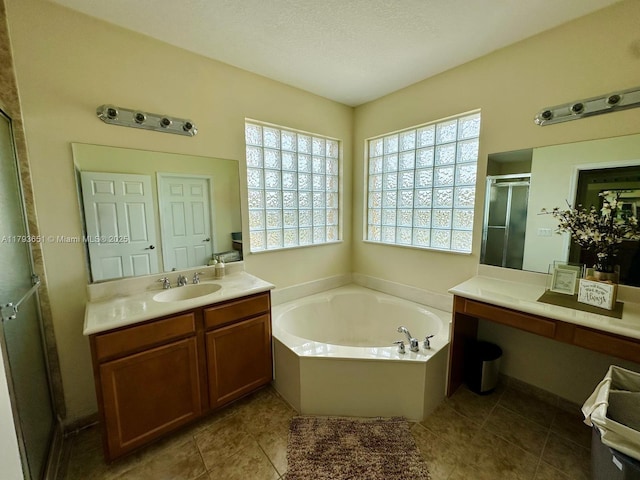 full bath featuring tile patterned floors, a shower stall, a garden tub, and vanity