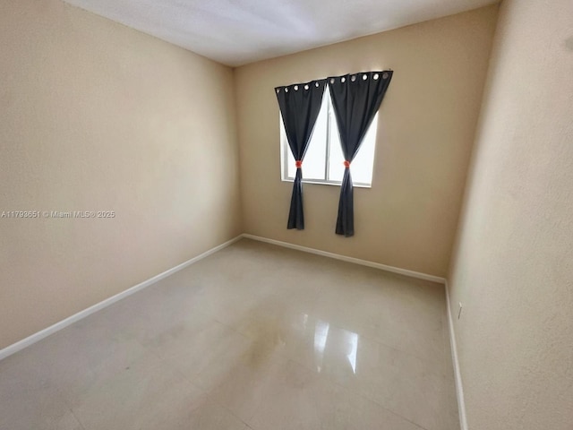 spare room with baseboards
