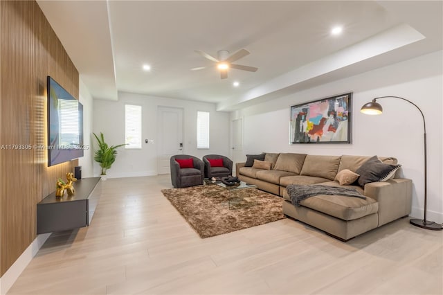 living room featuring wood walls, baseboards, recessed lighting, a ceiling fan, and light wood-style flooring