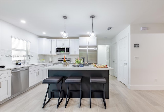 kitchen featuring visible vents, a sink, tasteful backsplash, and stainless steel appliances