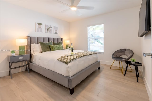 bedroom with baseboards, ceiling fan, and light wood-type flooring