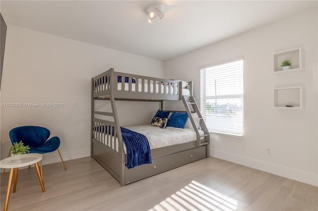 bedroom featuring baseboards and wood finished floors