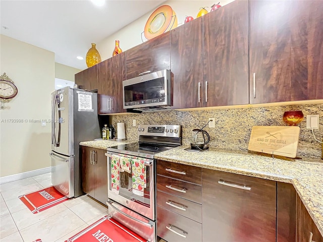 kitchen with baseboards, light tile patterned floors, light stone counters, backsplash, and stainless steel appliances