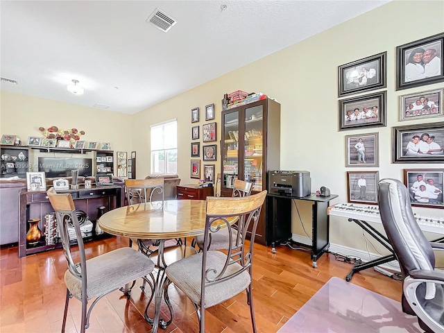 dining area featuring visible vents and light wood-style flooring
