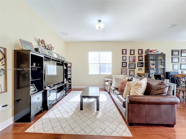 living area with baseboards and visible vents