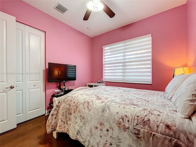 bedroom with a closet, a ceiling fan, wood finished floors, and visible vents