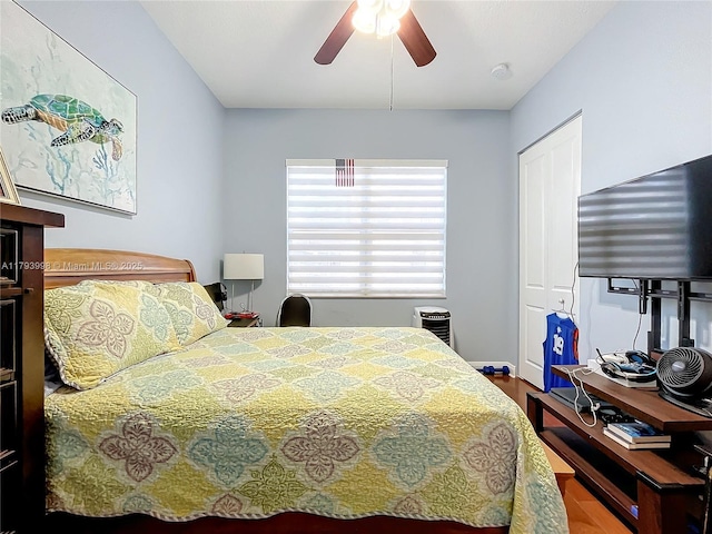 bedroom with a ceiling fan, a closet, and wood finished floors