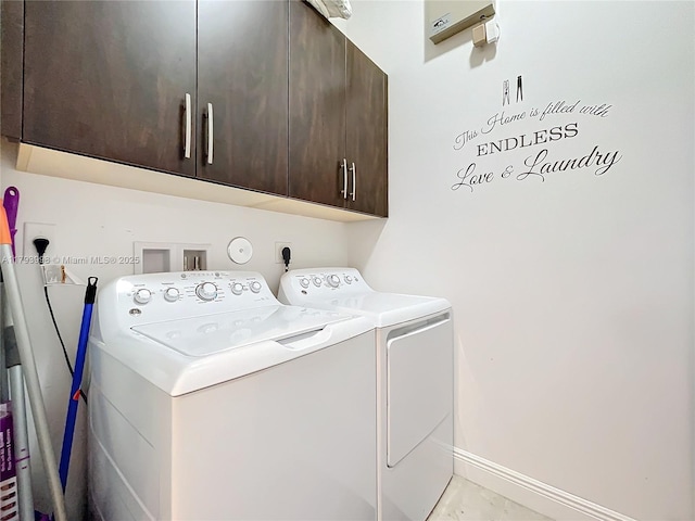 laundry area with baseboards, marble finish floor, cabinet space, and washing machine and clothes dryer