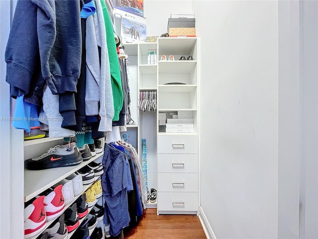 walk in closet with wood finished floors