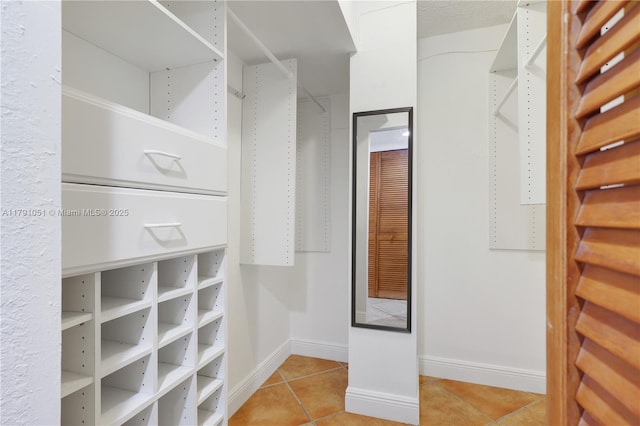 walk in closet with light tile patterned flooring