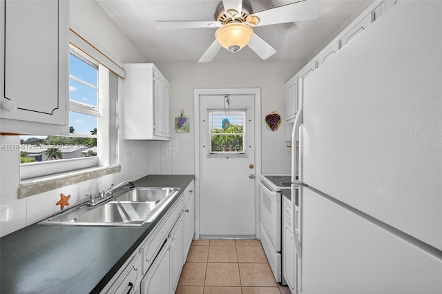 401 S Golf Blvd Unit 270, Pompano Beach, FL 33064 - kitchen with white appliances, white cabinets, dark countertops, tasteful backsplash, and light tile patterned flooring