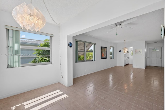 401 S Golf Blvd Unit 270, Pompano Beach, FL 33064 - unfurnished living room with a chandelier, tile patterned floors, healthy amount of natural light, and a textured ceiling