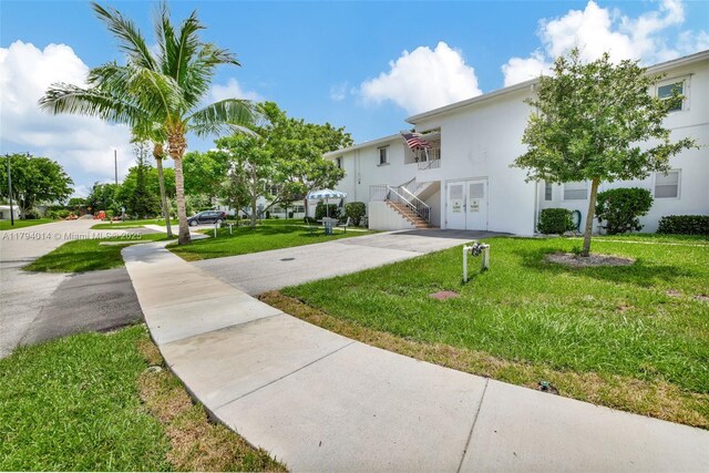 401 S Golf Blvd Unit 270, Pompano Beach, FL 33064 - view of front facade featuring stucco siding, a front lawn, stairway, and french doors